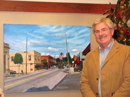 Doug Strickland stands by his painting 'Clayton Main Street' on display at the Capital Bank office in Clayton, NC